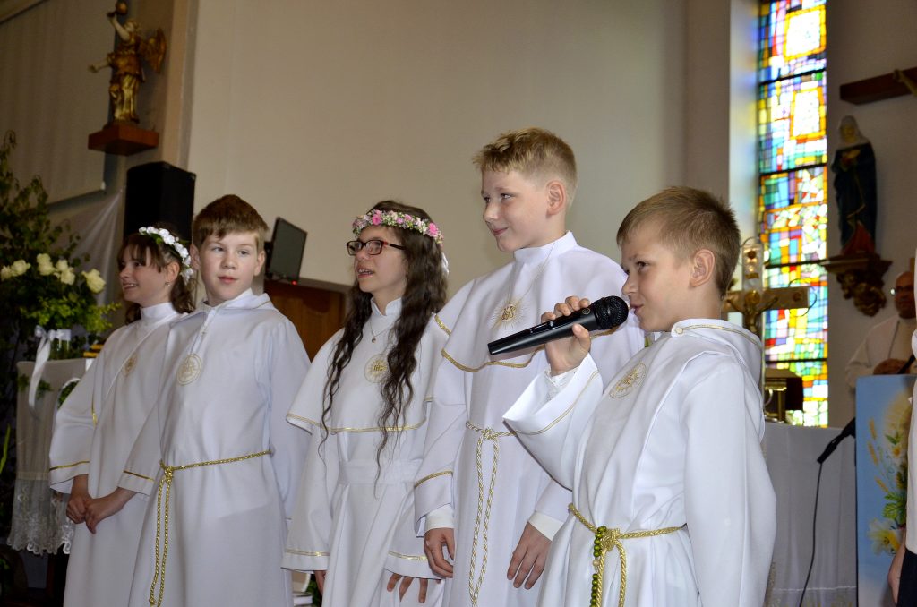 grupa małych dzieci śpiewających w kościele.