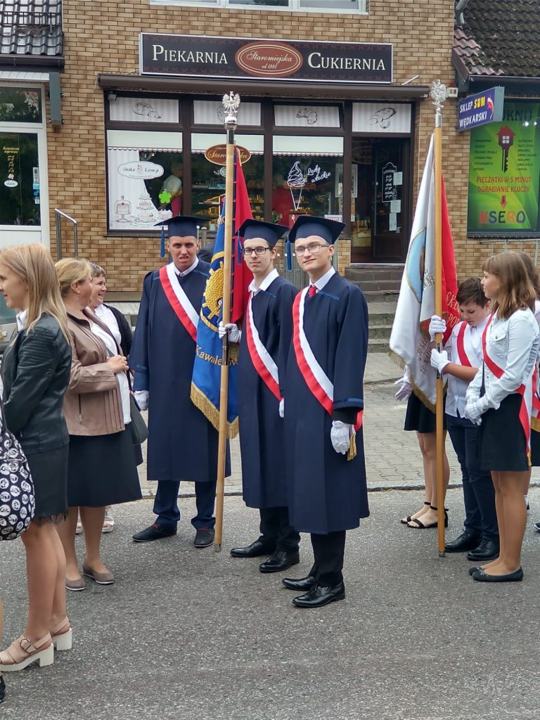 grupa ludzi stojących na ulicy.