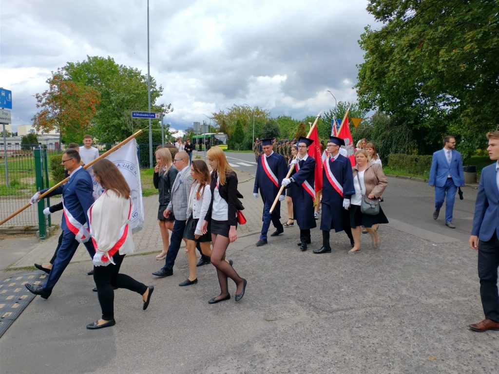 grupa ludzi idących ulicą z flagami.