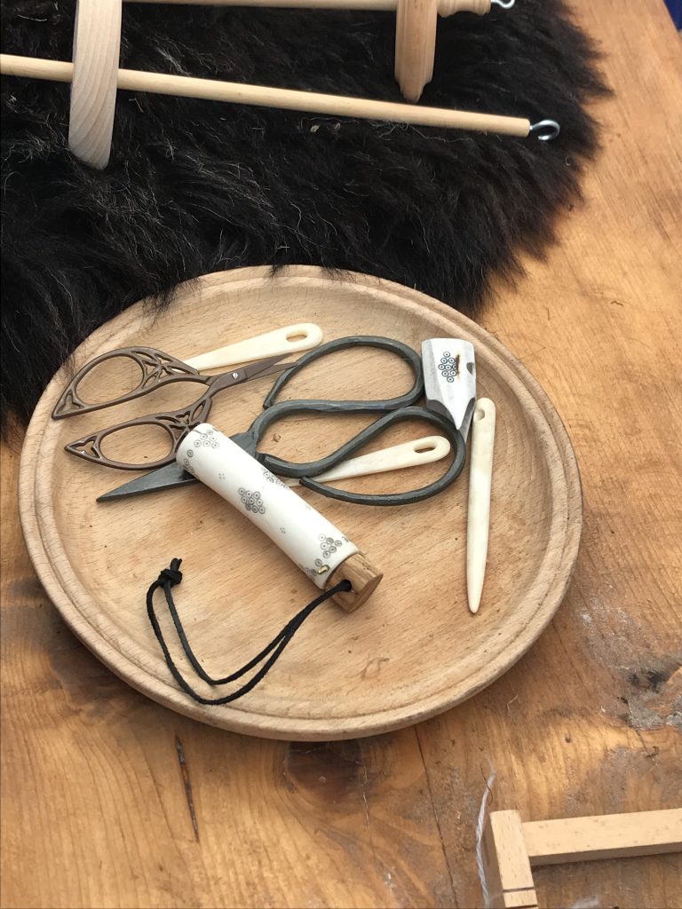 drewniany stół z nożyczkami i parą nożyczek.