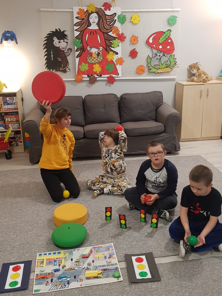 grupa dzieci bawiących się zabawkami w pokoju.