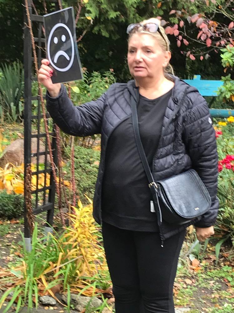 kobieta trzymająca tabliczkę ze smutną twarzą.