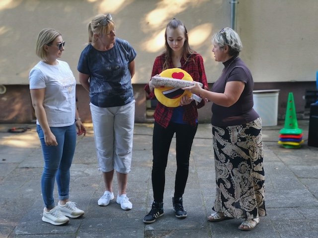 grupa kobiet stojących wokół siebie i trzymających frisbee.