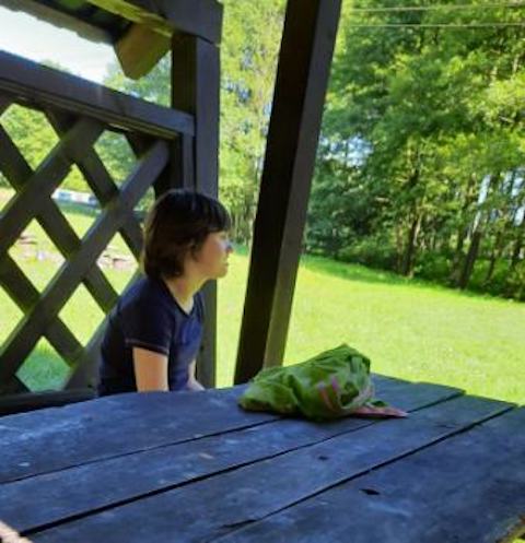mała dziewczynka siedzi przy stole piknikowym.