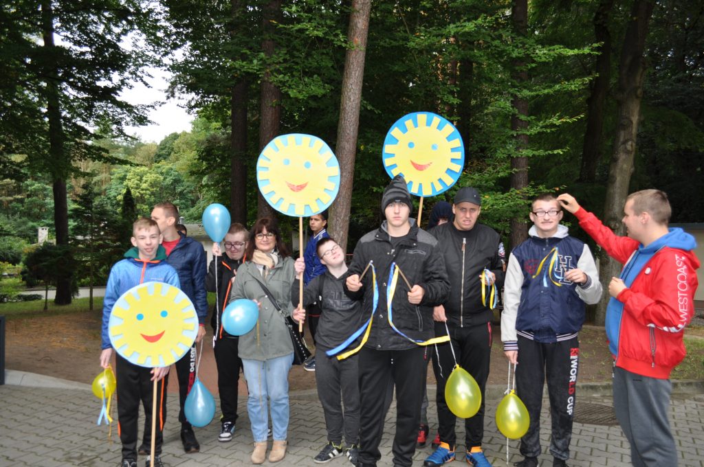 grupa młodych ludzi trzyma balony.