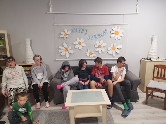grupa dzieci siedzi na kanapie w salonie.