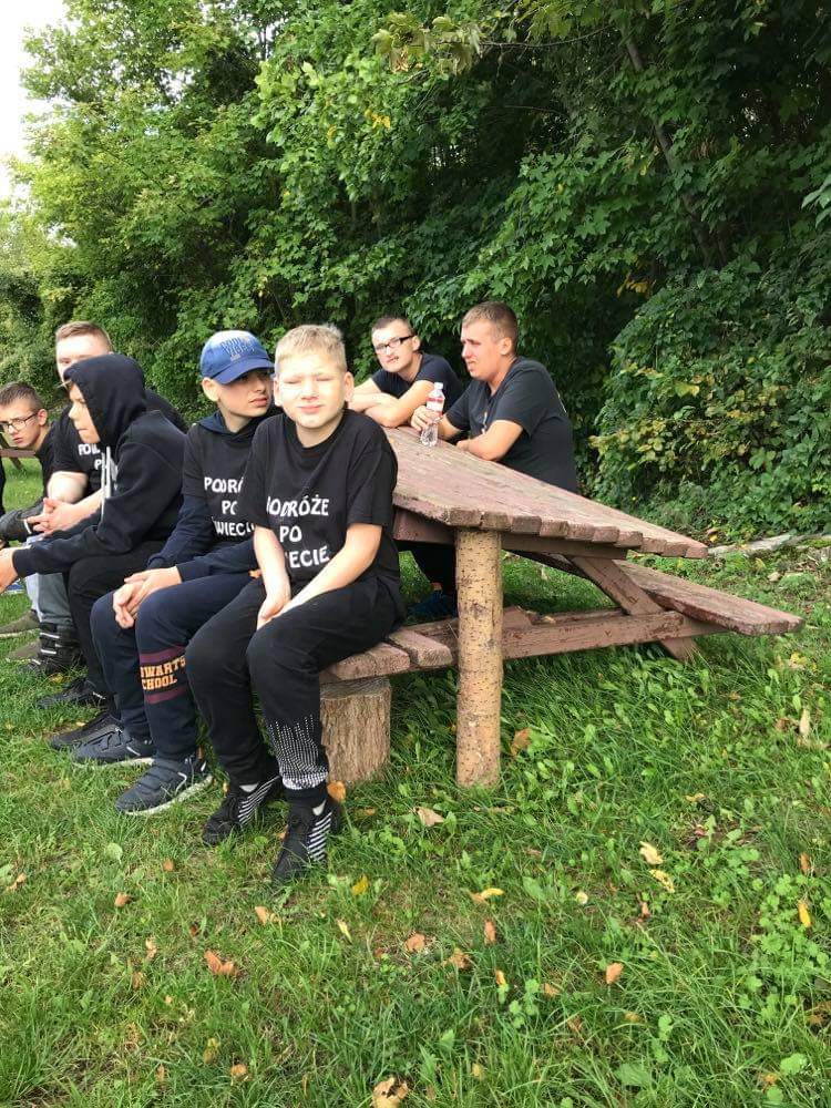 grupa ludzi siedzących na szczycie drewnianej ławki.