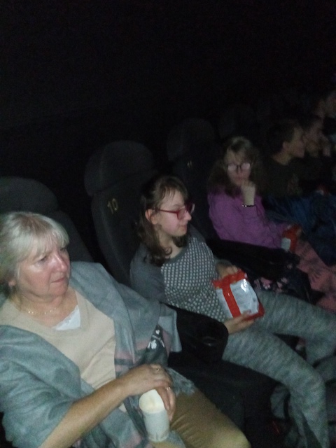 grupa ludzi siedzących w kinie.