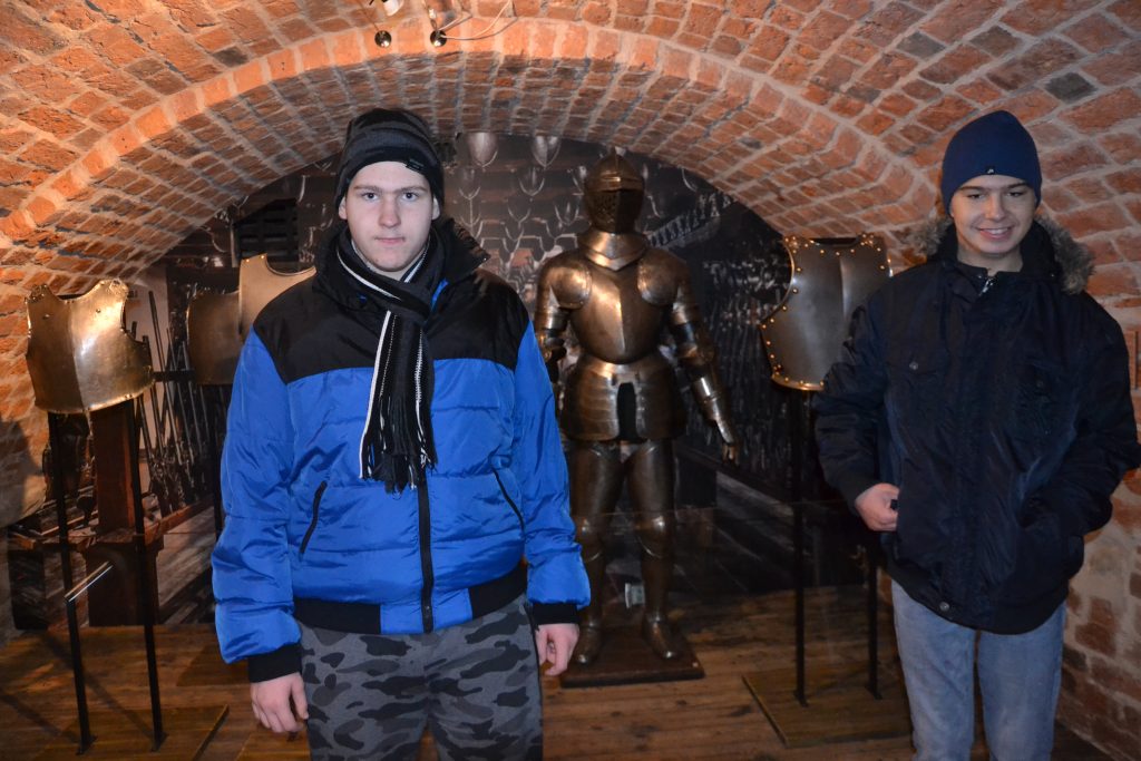 dwóch młodych mężczyzn stojących w ceglanym tunelu.