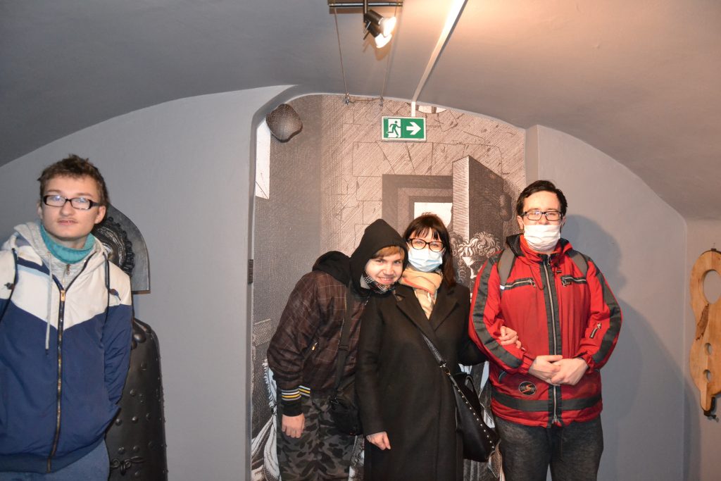grupa ludzi noszących maski na twarz w tunelu.