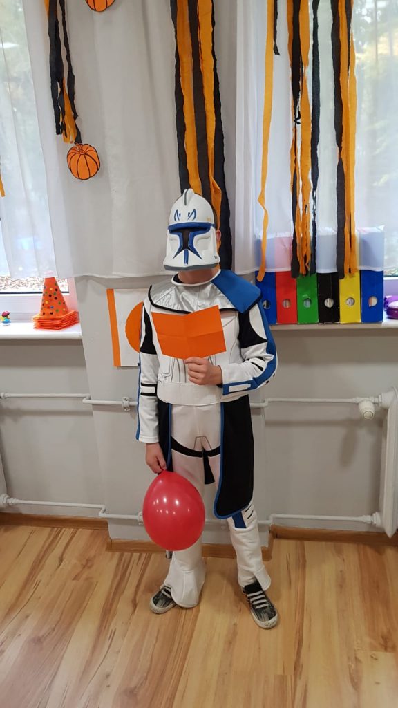 chłopiec przebrany za postać z Gwiezdnych wojen trzymający balon.