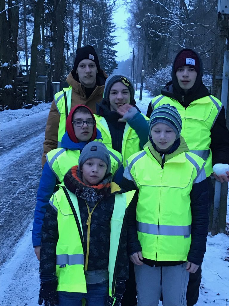 grupa ludzi stojących obok siebie na śniegu.