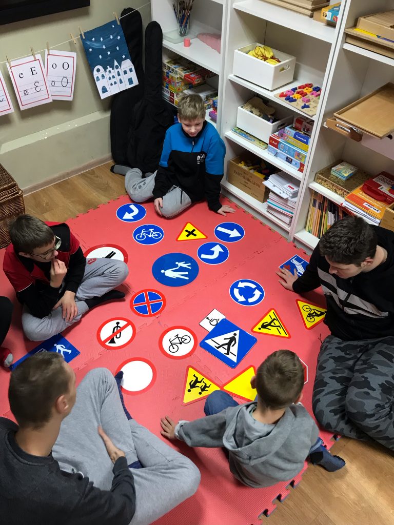 grupa dzieci siedzących na podłodze i grających w grę.