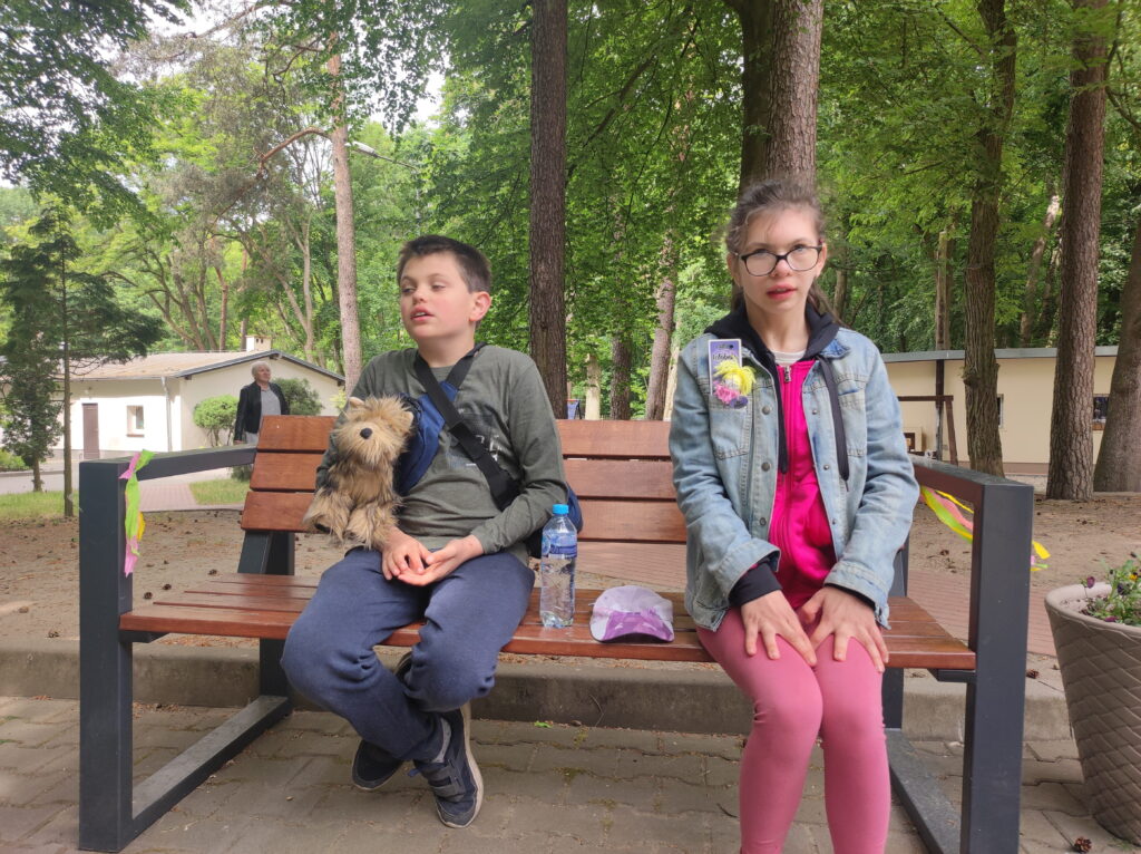 chłopiec i dziewczyna siedzi na ławce w parku.