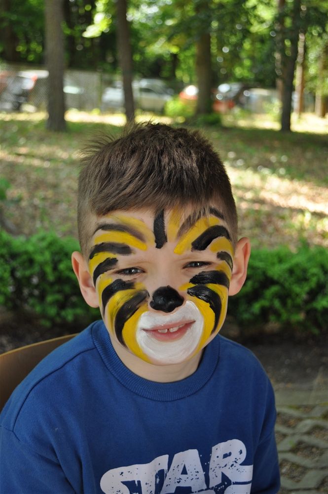 Chłopiec z pomalowaną twarzą na wzór tygrysa